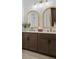 Elegant bathroom with double sink vanity featuring marble countertops, rattan mirrors, and stylish light fixtures at 4775 Wyat Farm Overlook, Cumming, GA 30040