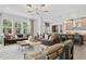 Bright living room with large windows, comfortable seating, and views into the kitchen, blending living and cooking spaces at 4775 Wyat Farm Overlook, Cumming, GA 30040