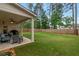 Spacious backyard featuring a well-maintained lawn, covered patio, and a charming, enclosed fence at 592 Eagles Nest Cir, Auburn, GA 30011