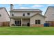 Exterior backyard featuring a covered patio with an outdoor kitchen, well-kept lawn, and privacy fence at 592 Eagles Nest Cir, Auburn, GA 30011