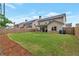 Backyard showcasing green lawn, covered patio, and a privacy fence, perfect for outdoor activities at 592 Eagles Nest Cir, Auburn, GA 30011
