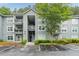Condominium exterior showing gray siding, white trim, balconies, mature trees, and wet parking lot at 6204 Santa Fe Pkwy, Atlanta, GA 30350