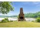 Stone fireplace overlooking the lake with surrounding green trees in a tranquil outdoor community space at 6204 Santa Fe Pkwy, Atlanta, GA 30350