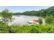 Scenic lake view with dock featuring kayaks and canoes with lush green trees surrounding the serene water at 6204 Santa Fe Pkwy, Atlanta, GA 30350
