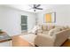 Cozy living room featuring a comfortable beige sofa, ceiling fan, and sliding door to a balcony at 6204 Santa Fe Pkwy, Atlanta, GA 30350