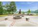 An outdoor fireplace featuring stone benches, stone columns, brick accents overlooking the lake and surrounding trees at 6204 Santa Fe Pkwy, Atlanta, GA 30350
