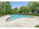 Beautiful community pool with a unique shape, surrounded by lush trees and landscaping at 6204 Santa Fe Pkwy, Atlanta, GA 30350