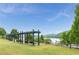 Relaxing lake view with shaded swinging benches surrounded by a wooden fence and lush green trees at 6204 Santa Fe Pkwy, Atlanta, GA 30350