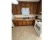 Well-lit kitchen with wooden cabinets, a double sink, and white appliances, offering practicality and style at 167 Mathews Se Cir, Marietta, GA 30067