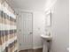 Bright bathroom with a pedestal sink and shower with striped curtain at 2759 Thomashire Trce, Marietta, GA 30066