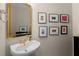 Charming powder room featuring a pedestal sink, gold mirror, and decorative wall art at 2759 Thomashire Trce, Marietta, GA 30066