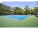 Well-maintained tennis court with new surface, surrounded by trees and fencing for privacy at 2759 Thomashire Trce, Marietta, GA 30066
