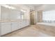 Primary bathroom with dual sinks, granite countertops, a glass-enclosed shower and soaking tub at 3182 Hartford Mill Pl, Duluth, GA 30097