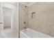 Bright bathroom featuring a tub with tiled walls and an open doorway to a walk-in closet at 3182 Hartford Mill Pl, Duluth, GA 30097
