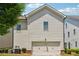 Back exterior view shows attached garage, manicured shrubbery and vinyl siding at 3182 Hartford Mill Pl, Duluth, GA 30097