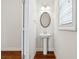 Stylish powder room featuring a pedestal sink, elegant mirror, and modern fixtures at 3182 Hartford Mill Pl, Duluth, GA 30097