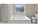 Bathroom featuring a large soaking tub and frosted window for added privacy at 804 Rose Creek Walk, Woodstock, GA 30189