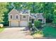 Charming two-story home features a two-car garage and a welcoming front entrance with lush landscaping and mature trees at 804 Rose Creek Walk, Woodstock, GA 30189