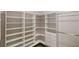 This walk-in closet features custom white shelving and drawers for optimal organization and storage at 900 Ellesmere Pt, Mcdonough, GA 30253