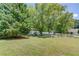 Spacious backyard featuring mature trees and a white picket fence, offering privacy at 2584 Gravitt Rd, Duluth, GA 30096