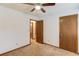 Neutral carpeted bedroom with ceiling fan and two wood finish doors, one leading to an adjacent room at 2584 Gravitt Rd, Duluth, GA 30096