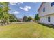 Expansive yard featuring green grass, trees, a white fence, and the side of a white house at 2584 Gravitt Rd, Duluth, GA 30096