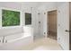 Modern bathroom featuring a glass-enclosed shower, a tub, and access to a walk-in closet at 3014 Volland Grove Trail, Lawrenceville, GA 30043