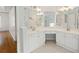 Bright bathroom boasts dual sinks, white cabinets, and a large, well-lit mirror at 3014 Volland Grove Trail, Lawrenceville, GA 30043