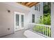 Charming outdoor deck with white railings and double glass doors, offering a serene view of lush greenery at 3014 Volland Grove Trail, Lawrenceville, GA 30043