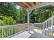 Relaxing outdoor deck featuring white railings, wood flooring and beautiful views of the backyard and surrounding trees at 3014 Volland Grove Trail, Lawrenceville, GA 30043