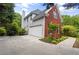 View of the home showing the driveway and garage, surrounded by trees at 3014 Volland Grove Trail, Lawrenceville, GA 30043