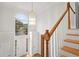 Bright foyer features beautiful chandelier, front door with sidelights, and staircase with wooden railing at 3014 Volland Grove Trail, Lawrenceville, GA 30043