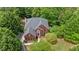 Aerial view of a brick two-story home with lush landscaping and a driveway at 3014 Volland Grove Trail, Lawrenceville, GA 30043