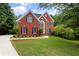 Beautiful red brick home featuring a well-manicured lawn and inviting curb appeal at 3014 Volland Grove Trail, Lawrenceville, GA 30043
