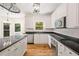 Well-equipped kitchen featuring white cabinets, black countertops, stainless steel appliances, and hardwood floors at 3014 Volland Grove Trail, Lawrenceville, GA 30043