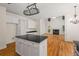 Open-concept kitchen with island, white cabinets, black countertops, and hardwood floors flowing into living room at 3014 Volland Grove Trail, Lawrenceville, GA 30043