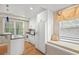 Updated kitchen with white cabinets, modern appliances, breakfast bar, window seat, and hardwood floors at 3014 Volland Grove Trail, Lawrenceville, GA 30043