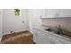 Laundry room featuring white cabinets, granite countertop, stainless steel sink and wood flooring at 3014 Volland Grove Trail, Lawrenceville, GA 30043