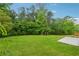 Large grassy backyard surrounded by mature trees and a concrete pad at 3757 Cindy Dr, Douglasville, GA 30135