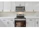 Modern kitchen with stainless steel appliances, white cabinetry, and sleek countertops, perfect for cooking and entertaining at 3757 Cindy Dr, Douglasville, GA 30135
