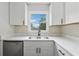 Well-lit kitchen sink area featuring white cabinets, black hardware, and a view of the outdoor scenery at 3757 Cindy Dr, Douglasville, GA 30135