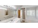 Well-lit bathroom with dual vanity, a large mirror, separate shower, and soaking tub near a window at 4912 Lightwood Nw Ct, Acworth, GA 30102