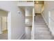 Bright entryway with light gray wood floors, white walls, and a carpeted staircase leading to the second floor at 4912 Lightwood Nw Ct, Acworth, GA 30102