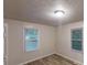 Neutral bedroom featuring wood laminate flooring and natural light from two large windows at 7125 Puckett Sw St, Covington, GA 30014