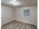 Empty bedroom with wood-look flooring and a large window at 7125 Puckett Sw St, Covington, GA 30014