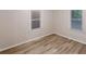 Bright bedroom featuring new wood flooring and natural light from two large windows at 7125 Puckett Sw St, Covington, GA 30014