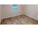 Bright bedroom features wood-look floors, a window, and neutral paint at 7125 Puckett Sw St, Covington, GA 30014