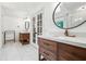 A bathroom featuring dual sink vanities and a large round mirror above a modern farmhouse faucet at 9545 Kingston Crossing Cir, Alpharetta, GA 30022
