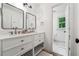 Bright bathroom features a white double vanity with modern hardware, a tile floor, and an adjacent toilet room at 9545 Kingston Crossing Cir, Alpharetta, GA 30022