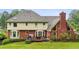 A back view of a house with a well manicured lawn and an open deck at 9545 Kingston Crossing Cir, Alpharetta, GA 30022